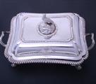 A William IV sterling silver entree dish and cover with armorial finial on electroplate two handled stand