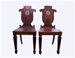 A good pair of George IV mahogany armorial hall chairs attributed to T & G Seddon