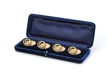 A fine and rare set of four George V 9ct rose gold armorial menu holders